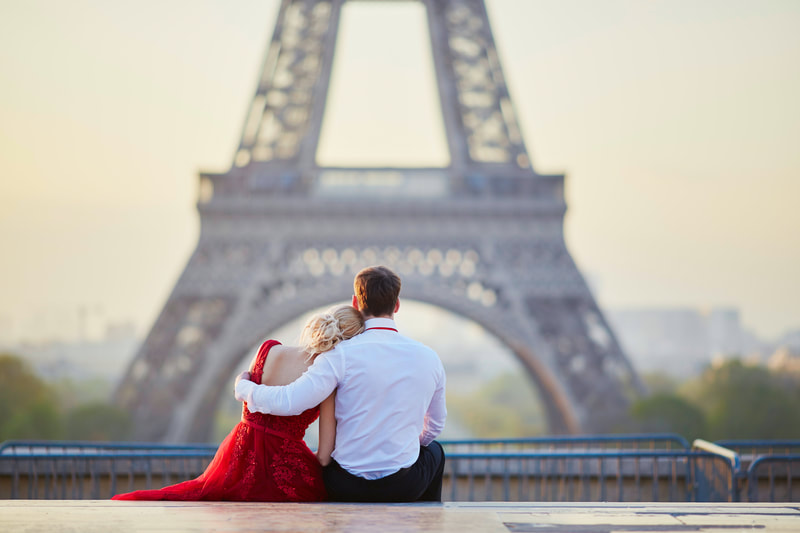 Couple seating and looking at the Eiffel Tower. 