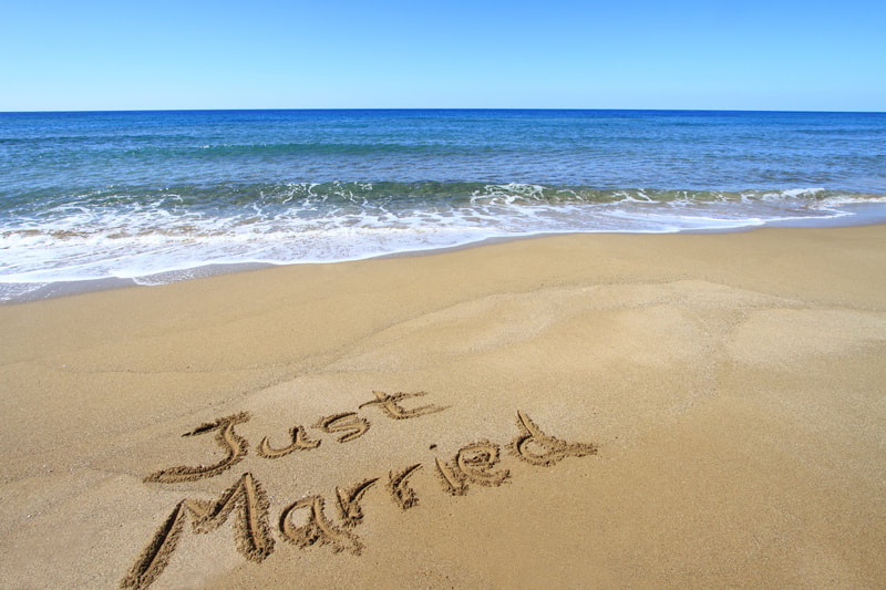 Just Married written on the sand. 