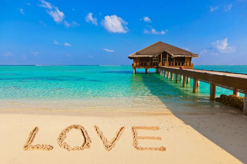 "LOVE" written in sand on the beach
